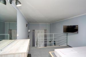 基辅Grand Apartments的卧室配有一张床,墙上配有电视。