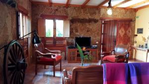因赫尼奥Casa Rural El Lirón的客厅配有电视、沙发和椅子