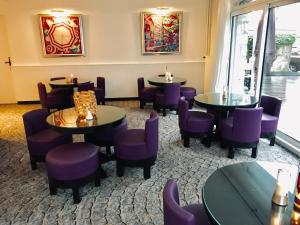 安锡堪塔帕酒店的一间餐厅,房间内设有紫色椅子和桌子