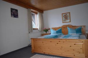 黑林山区邦多夫Pension Schüler的一间卧室配有一张带蓝色枕头的大型木制床。