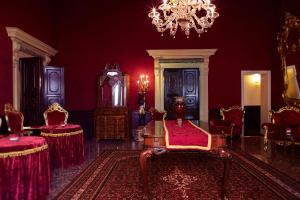 威尼斯Palazzo Paruta & Wellness Suites的一间设有红色墙壁和椅子及吊灯的房间
