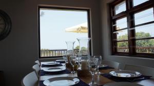 德班Villa 93的餐桌,带玻璃杯和盘子,窗户