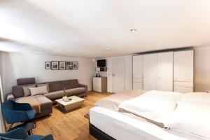 林道Maximilian Apartments Lindau的一间卧室配有一张床和一张沙发