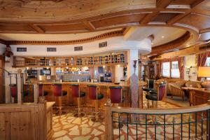 扎奥岑湖阿本玫瑰酒店的餐厅内的酒吧设有木制天花板和酒吧凳子