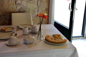 拉古萨瑞莱斯席米拉住宿加早餐乡村民宿的一张带馅饼和花瓶的白色桌子