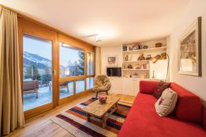 弗利姆斯Casa Alpetta的客厅设有红色的沙发和大窗户