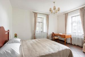 德鲁斯基宁凯BURMISTRO NAMAS的卧室配有一张床、一张书桌和窗户。