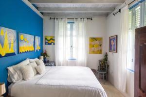 Pont Cassé和谐别墅酒店的卧室配有白色大床和蓝色的墙壁