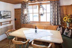 萨尔巴赫Chalet Appartement Alpenherz的一间带木桌和椅子的用餐室