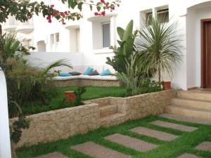 拉腊什Villa El Andalousse的一座花园,在建筑的一侧设有长凳
