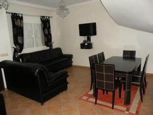 拉腊什Villa El Andalousse的客厅配有黑色桌椅和沙发