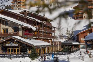 美贝尔瓦隆峰酒店的滑雪场旁雪地中的滑雪小屋