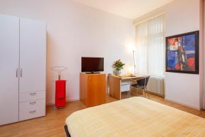 卢塞恩Residence zur Musegg的一间卧室配有一张床和一张书桌及电视