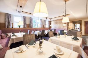 阿尔布斯塔特Gasthof Linde的餐厅配有白色的桌椅和灯光