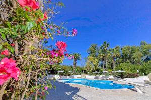 马丁纳弗兰卡Villa del Sole Martina Franca的一个带粉红色花卉游泳池的度假酒店