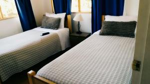 CatapilcoCasa de Campo Catapilco的配有蓝色窗帘的客房内的两张床