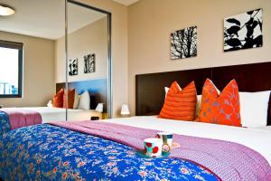 悉尼Quest Mascot的一间卧室配有一张带橙色和蓝色枕头的大床