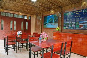 宁平Tam Coc Legend Hotel的一间带桌椅和菜单的餐厅