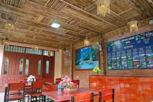 宁平Tam Coc Legend Hotel的餐厅设有木桌椅和菜单
