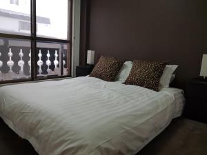 饭山市Chill Madarao的卧室配有带枕头的白色床和窗户。