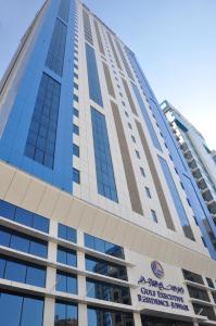 麦纳麦Gulf Executive Hotel & Residence Juffair的一座高大的建筑,上面有标志