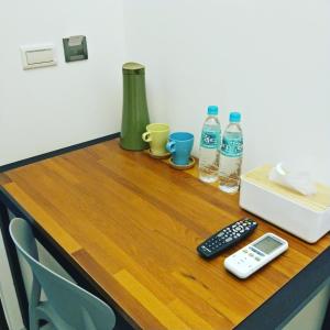 花莲市欧吧旅宿的一张带遥控器的桌子和两瓶水