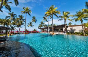 蔻立Ramada Resort by Wyndham Khao Lak的度假村内一座种有棕榈树的大型游泳池