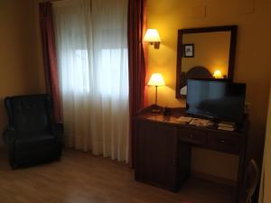 维赫恩-瓦拉加贝桑安杜哈尔山酒店的酒店客房设有电视和带椅子的书桌