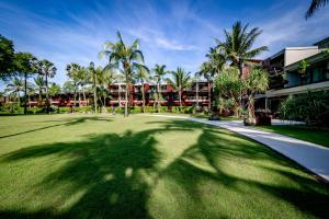 蔻立Ramada Resort by Wyndham Khao Lak的高尔夫球场上棕榈树的阴影