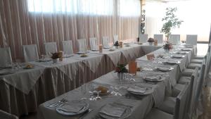 马里利亚诺Hotel Elio的一组长桌,配有白色的桌布和椅子