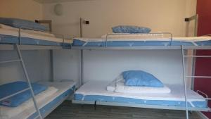 希茨海尔斯松比斯特兰德野营客房假日公园的客房设有三张双层床和蓝色枕头。