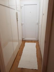 尼赖吉哈佐Lia Apartman的一条带白色门和白色地毯的走廊