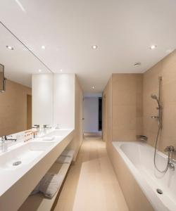 沃韦沃韦摩登时代酒店的浴室配有两个盥洗盆和浴缸。
