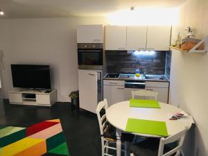 蒂宾根Ruhige Wohnung in zentraler Lage Tübingens的一间带白色桌子的厨房和一间带电视的厨房