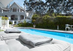 克尼斯纳帕克斯庄园酒店的一座房子旁的游泳池,配有两把躺椅