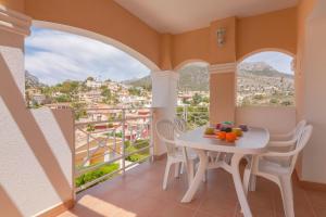 卡尔佩Villas Guzman - Dora的设有一个配有桌椅并享有美景的阳台。