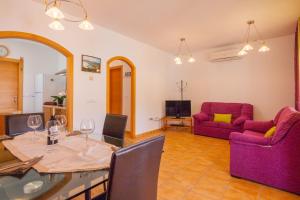 卡尔佩Villas Guzman - Dora的客厅配有餐桌和紫色家具