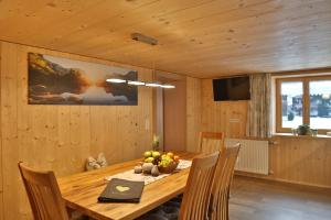 梅劳Apartments Hänsler的一间带木桌和椅子的用餐室