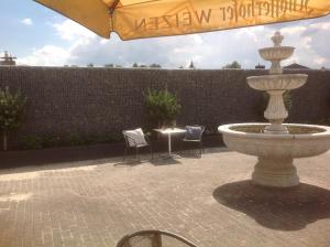 格罗瑙弗里茨酒店餐厅的一个带椅子和桌子的庭院内的喷泉