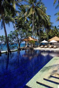 特贾库拉Spa Village Resort Tembok Bali - Small Luxury Hotels of the World的棕榈树游泳池及度假村