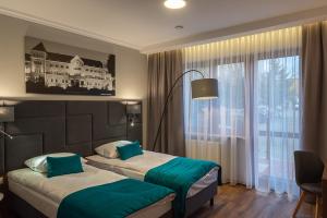 波兹南波兹南中心托帕兹酒店的酒店客房设有两张床和窗户。