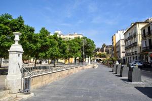 马拉加LyriosHomes Málaga La Merced Centro的城市中有人行道,有栅栏和树木