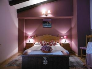 里瓦德奥Casa Benito的一间卧室设有一张紫色墙壁的大床