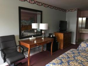 Lovingston乡村汽车旅馆的酒店客房配有书桌、椅子和镜子