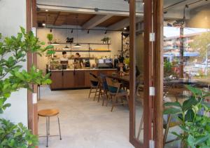 奥南海滩TAN Hostel x Cafe , Aonang Beach的一间带桌椅和柜台的餐厅