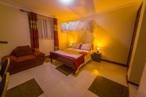 恩德培Hotel Royal Nest Entebbe的一间卧室配有一张床和一把椅子