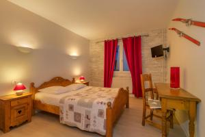 莱鲁斯Hôtel La Redoute的一间卧室配有一张床、一张书桌和一个窗户。