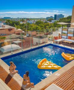 坎昆Nomads Hotel, Hostel & Rooftop Pool Cancun的两个女人在度假村的游泳池里