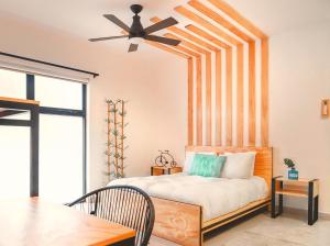 坎昆Nomads Hotel, Hostel & Rooftop Pool Cancun的一间卧室配有一张带吊扇的床