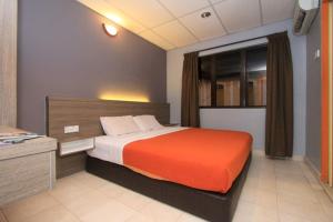 马六甲Yellow Mansion Hotel的一间卧室配有一张带橙色毯子的大床